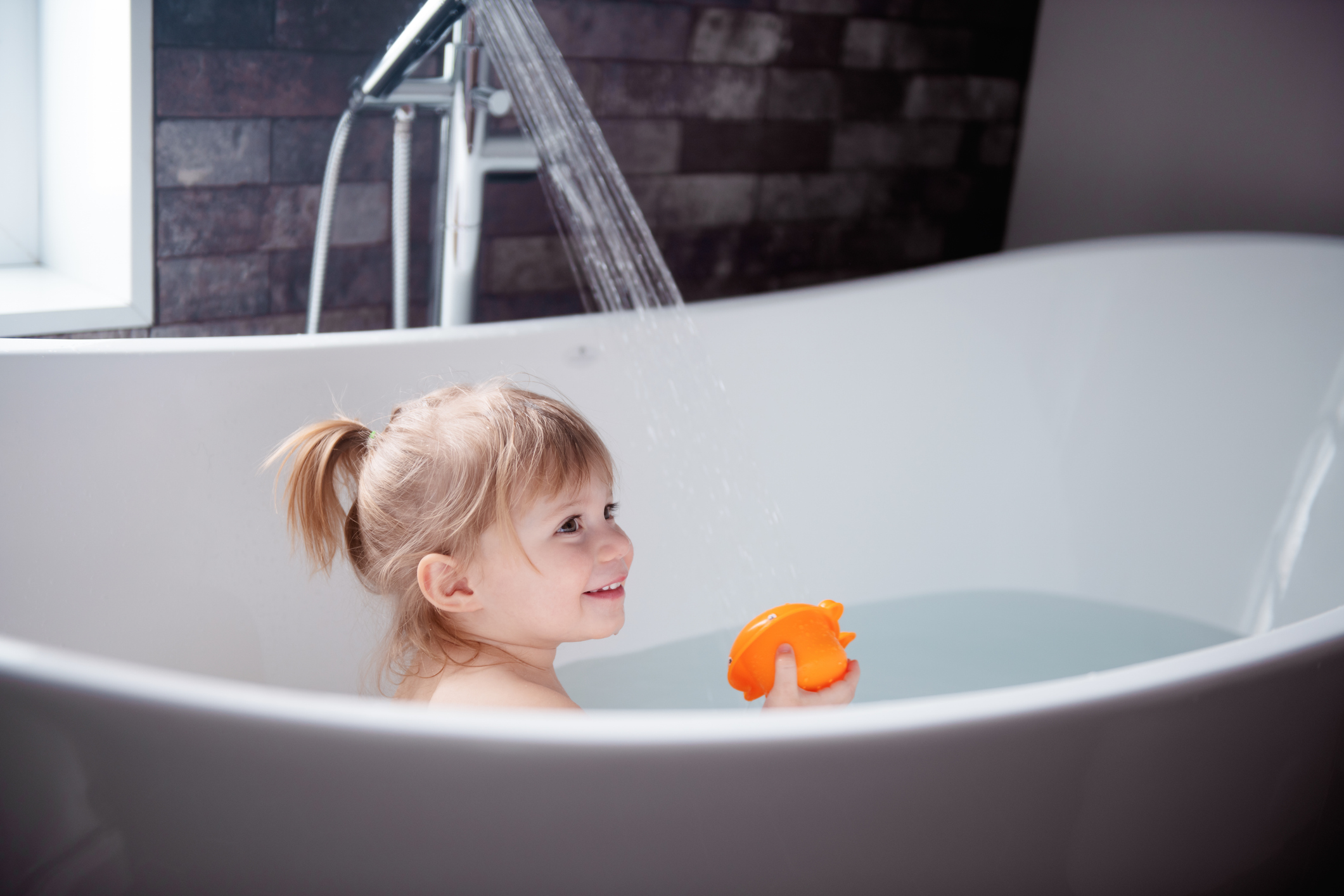 Cute little girl playing in a bathtub
