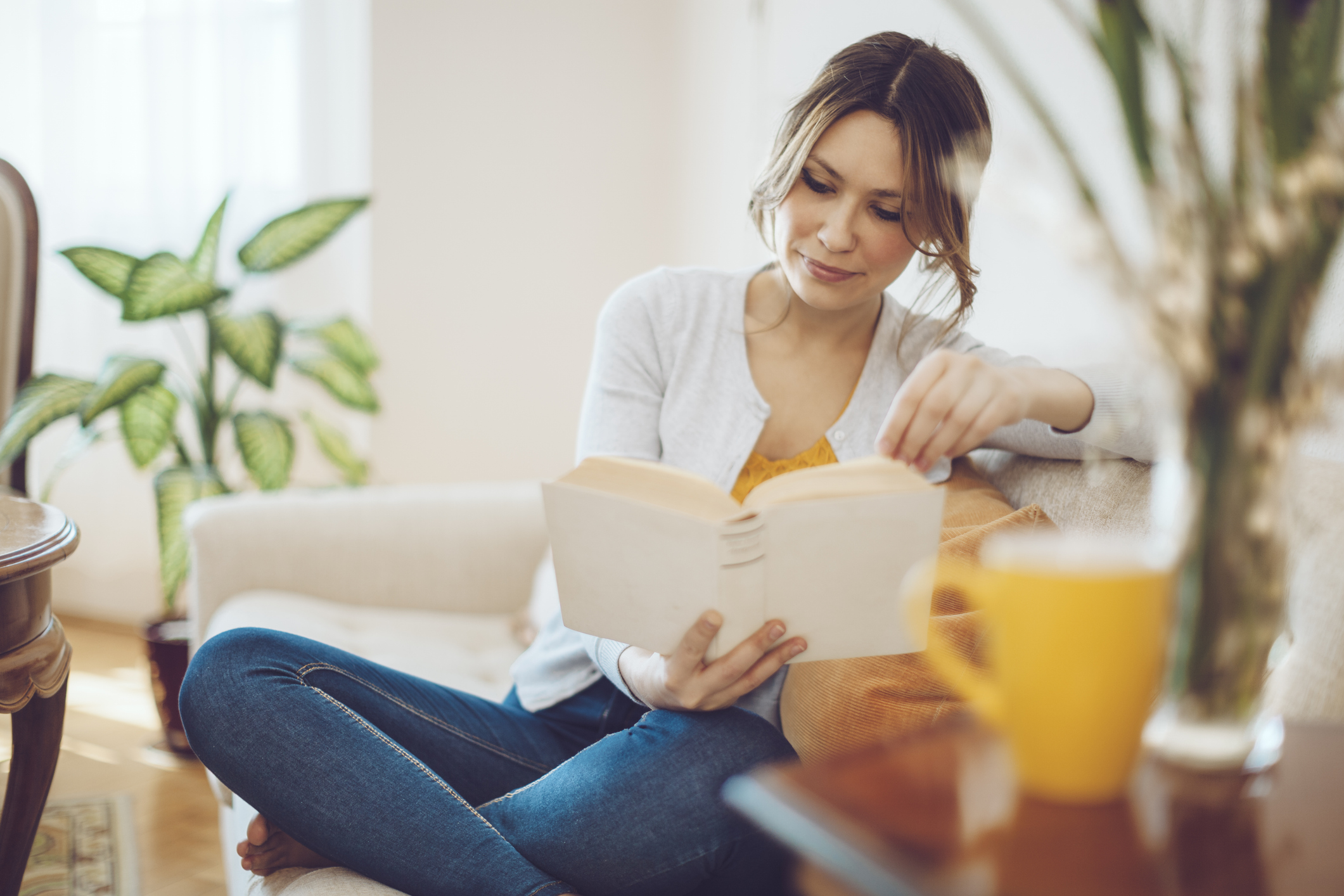 Beautiful latin woman reading a book at home